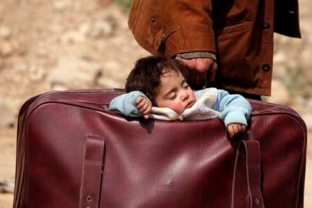 Un niño duerme dentro de una maleta en Beit Sawa (Siria).