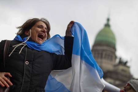 Una mujer porta una bandera argentina en favor a la vida.