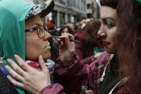 Dos mujeres se maquillan como parte de la manifestación a favor del aborto legal.