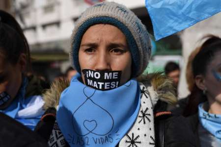 Una mujer lleva en su cuello el pañuelo celeste con la consigna "Salvemos las dos vidas"