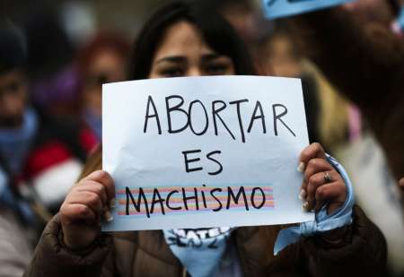 Una joven exhibe un lema antiaborto legal.