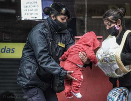 Mamá fue al Correo y una policía cuidó a su bebé para que entre a cobrar el bono