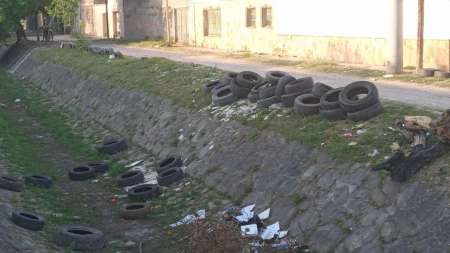Multaron a una gomería por tirar neumáticos en desuso en un canal