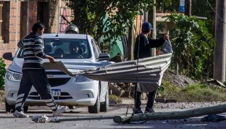 Vecinos de villa Asunción levantaban las chapas que se volaron por el viento de ayer. Pablo Yapura.